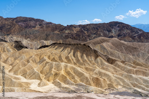 View of Zabriskie Point in Death Valley National Park in California, United States. Zabriskie Point is a part of the Amargosa Range located east of Death Valley noted for its erosional landscape.  photo