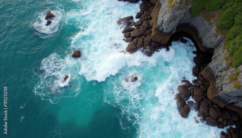 Coastal scenery with dramatic waves crashing against rocks. Turquoise water laps around dark gray rocks creating serene view. Ocean water looks peaceful. Its overlook of stunning coastal beauty. photo