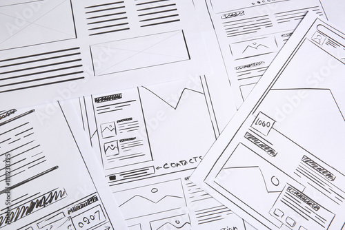 Developing UI design. Sketches of website wireframes as background, above view photo