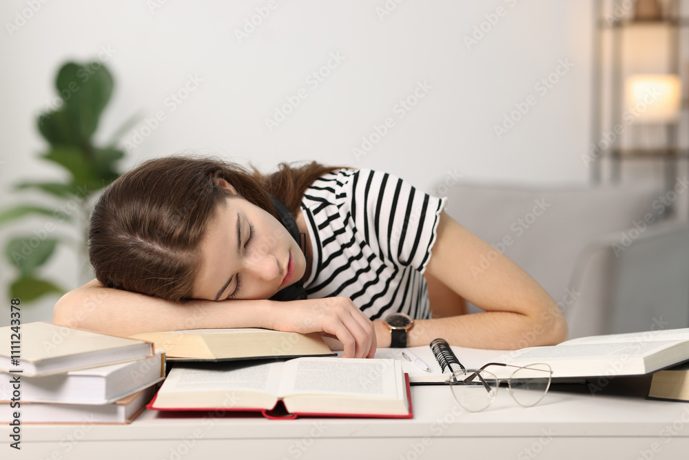 Preparing for exam. Tired student sleeping among books at table indoors Preparing for exam. Tired student sleeping among books at table indoors