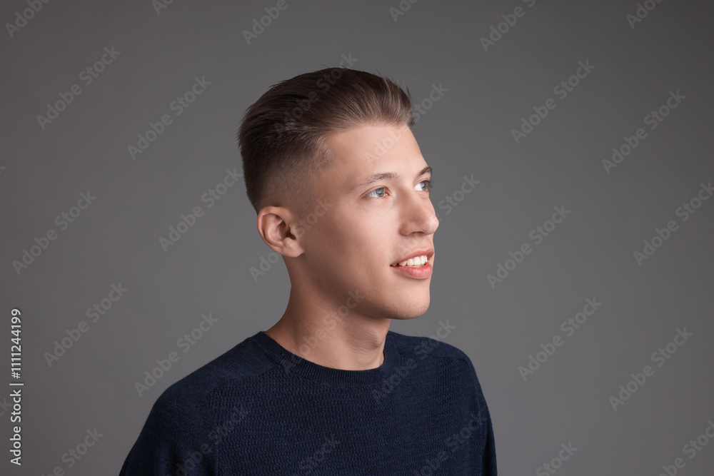 Fototapeta premium Handsome young man with stylish haircut on grey background