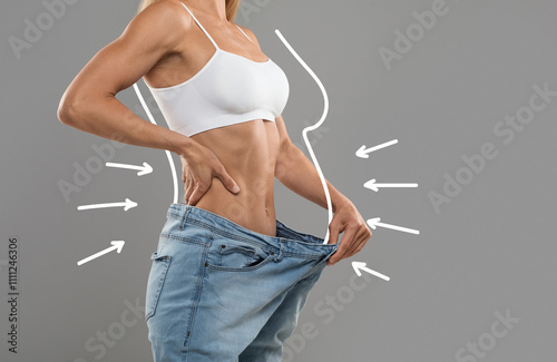 Fotografie Young Slim Female Pulling Big Jeans And Showing Result Of Weight Loss With Drawn