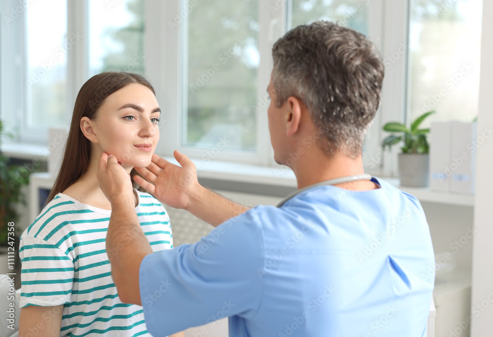 Doctor examining woman's throat in clinic during appointment Doctor examining woman's throat in clinic during appointment
