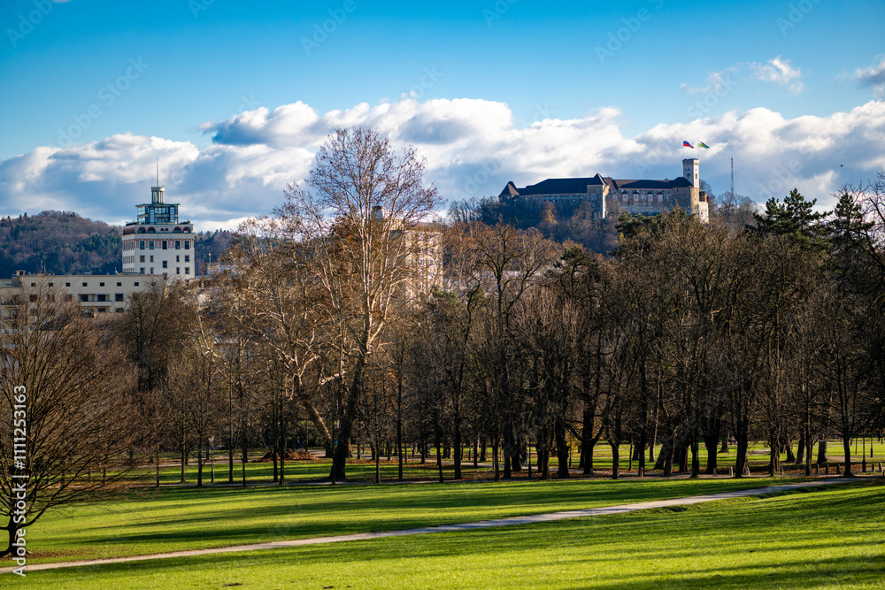 scenic view from a hill overlooking Ljubljana, with lush green grass in the foreground and trees in the middle ground. In the distance, the iconic Ljubljana Castle stands under a blue sky scenic view from a hill overlooking Ljubljana, with lush green grass in the foreground and trees in the middle ground. In the distance, the iconic Ljubljana Castle stands under a blue sky
