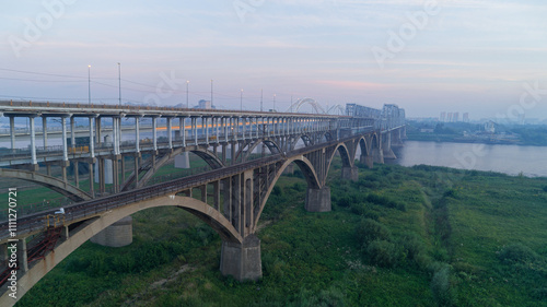 Bridge spans a river with a city in the background