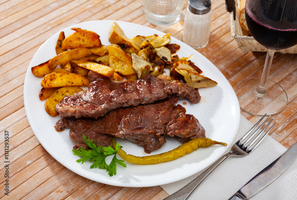 Healthy dinner, veal steak baked in oven with potato, artichokes and pickled pepper Healthy dinner, veal steak baked in oven with potato, artichokes and pickled pepper