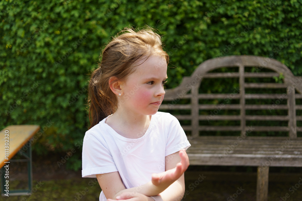 Beautiful cheerful girl in a white T-shirt having fun in the summer outdoors. Concept of an active, mobile, sincere child Beautiful cheerful girl in a white T-shirt having fun in the summer outdoors. Concept of an active, mobile, sincere child