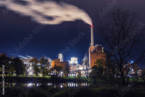 Factory by the river works at night