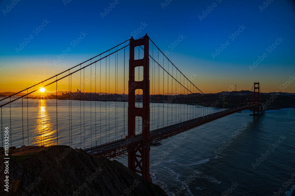 FEBRUARY 2023, SAN FRANCISCO, CA - sunrise view of famous Golden Gate bridge from Mill Valley side looking twards city shows traffic lights crossing bridge FEBRUARY 2023, SAN FRANCISCO, CA - sunrise view of famous Golden Gate bridge from Mill Valley side looking twards city shows traffic lights crossing bridge