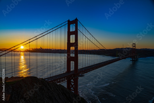 FEBRUARY 2023, SAN FRANCISCO, CA - sunrise view of famous Golden Gate bridge from Mill Valley side looking twards city shows traffic lights crossing bridge photo