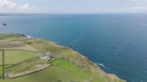 Rising aerial view of St Materiana's Church, highlighting its historic architecture amidst scenic coastal surroundings, Tintagel, UK photo