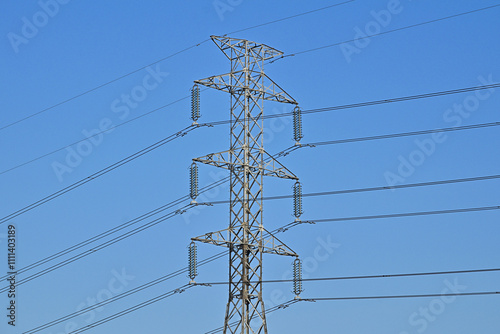 Voltage power lines or high voltage electric transmission tower with blue sky