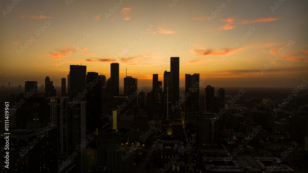 Fototapeta premium JULY 16, 2023, silhouette aerial view of Houston, Texas skyline at sunset