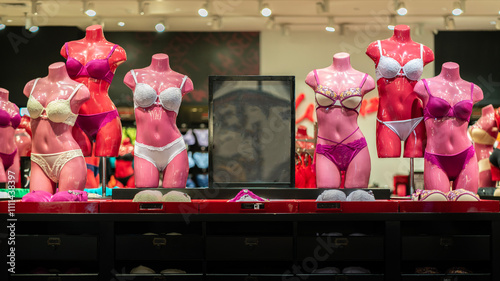 Pink female mannequins show different color and type lace bra and panties. Racks with sexy underwear in lingerie store