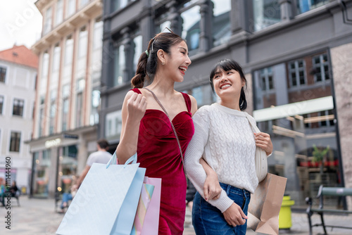 Asian two woman holding shopping bags and walking at outdoors marketplace. 