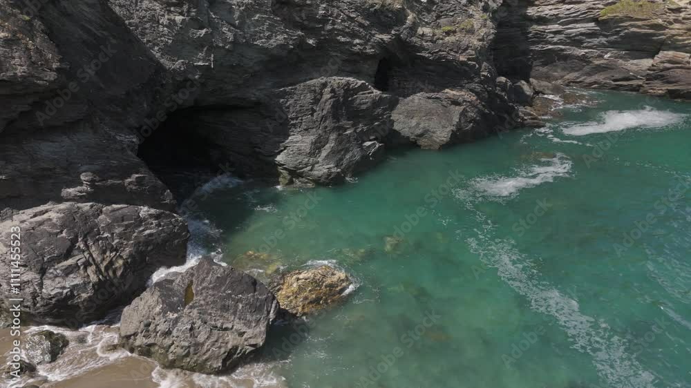 Aerial orbital of Merlin’s Cave, situated below the legendary Tintagel Castle, rumored to be King Arthur’s castle, Cornwall, UK Aerial orbital of Merlin’s Cave, situated below the legendary Tintagel Castle, rumored to be King Arthur’s castle, Cornwall, UK