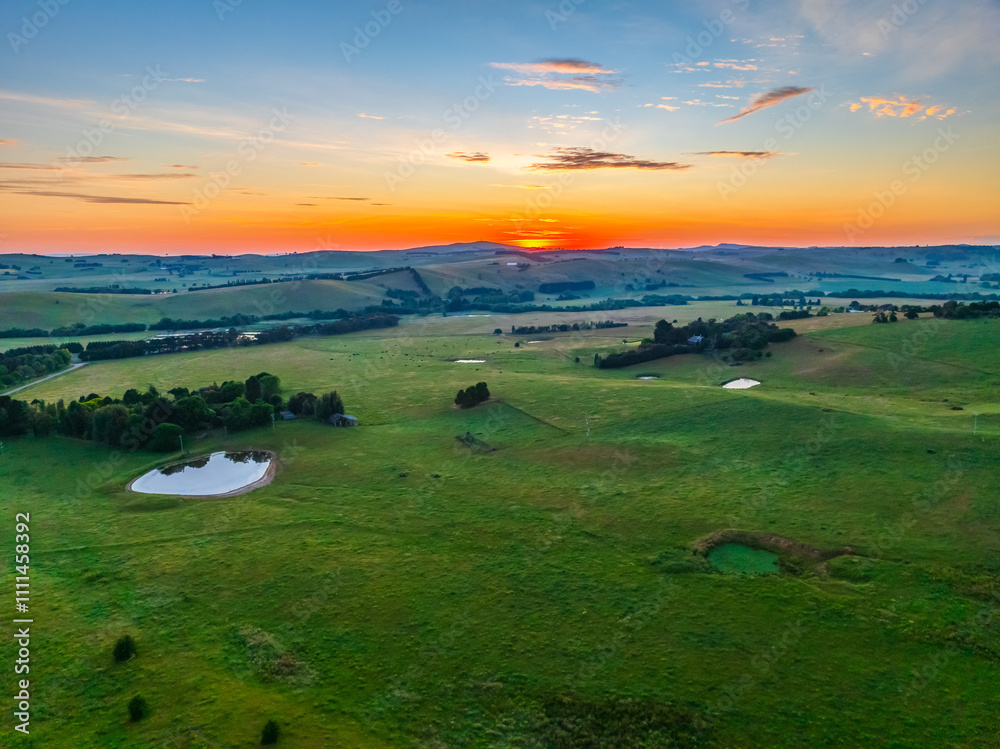 Fototapeta premium Sunrise over the countryside on the outskirts of country town with high cloud