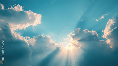 Bright sunlight rays shining through fluffy clouds in blue sky