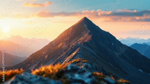 A stunning mountain peak illuminated by soft sunset light, surrounded by a breathtaking landscape of distant mountains and valleys.