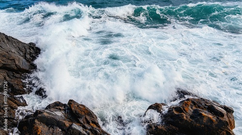 Dynamic ocean waves crashing against rugged rocks, creating a dramatic coastal scene filled with energy and movement.