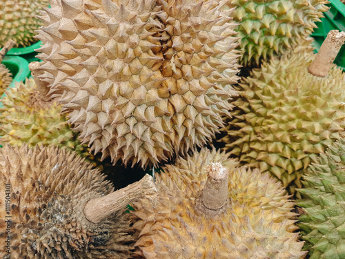 Close-up view of a pile of fresh and ripe durian fruits at a market stall. Durian Fruits in a Market Stall for Sale. Fresh durian freshly harvested from local photo