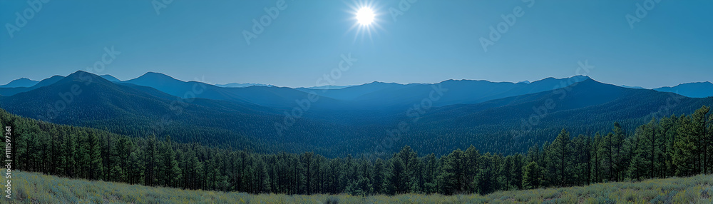 Panoramic view of sunlit mountain range and forest. Panoramic view of sunlit mountain range and forest.