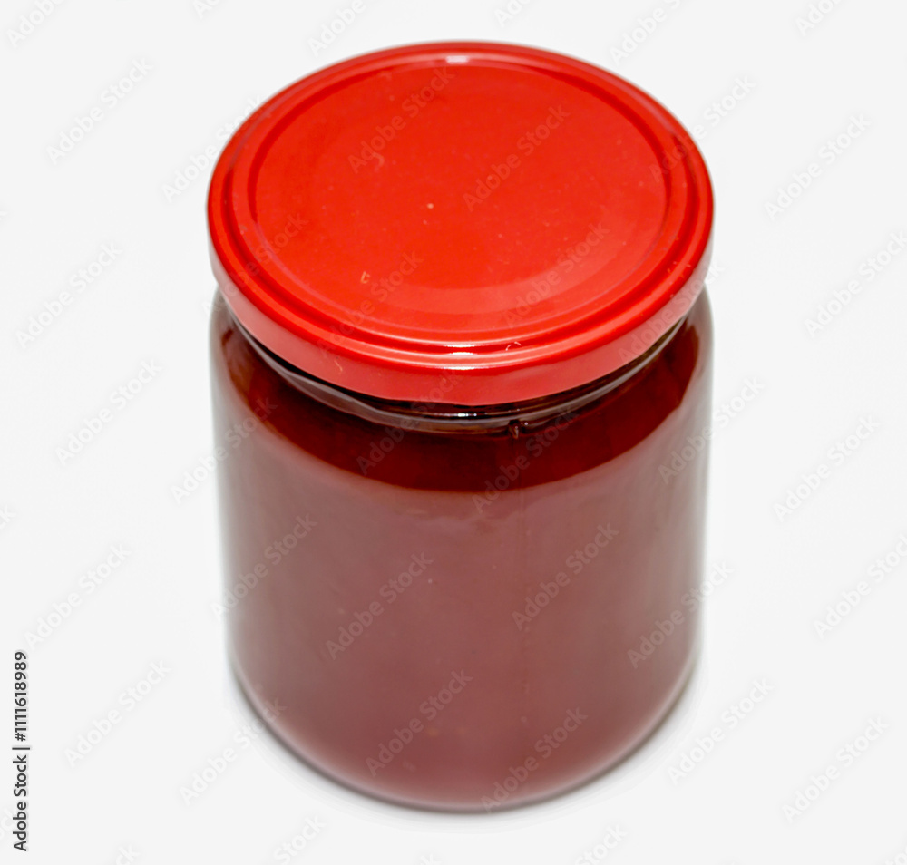 A jar of red sauce sits on a white background A jar of red sauce sits on a white background