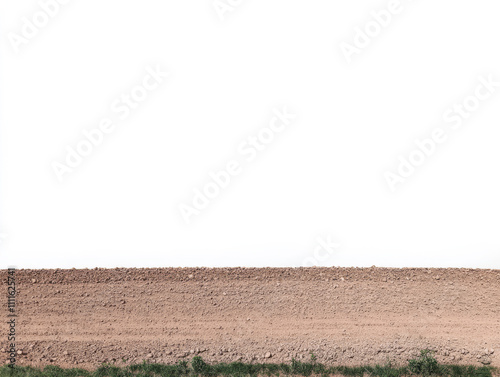 Brown dirt field under clear sky with a hint of green grass at the edge of the land photo