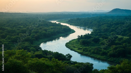 Serpentine river flowing through lush green forest landscape at sunrise.