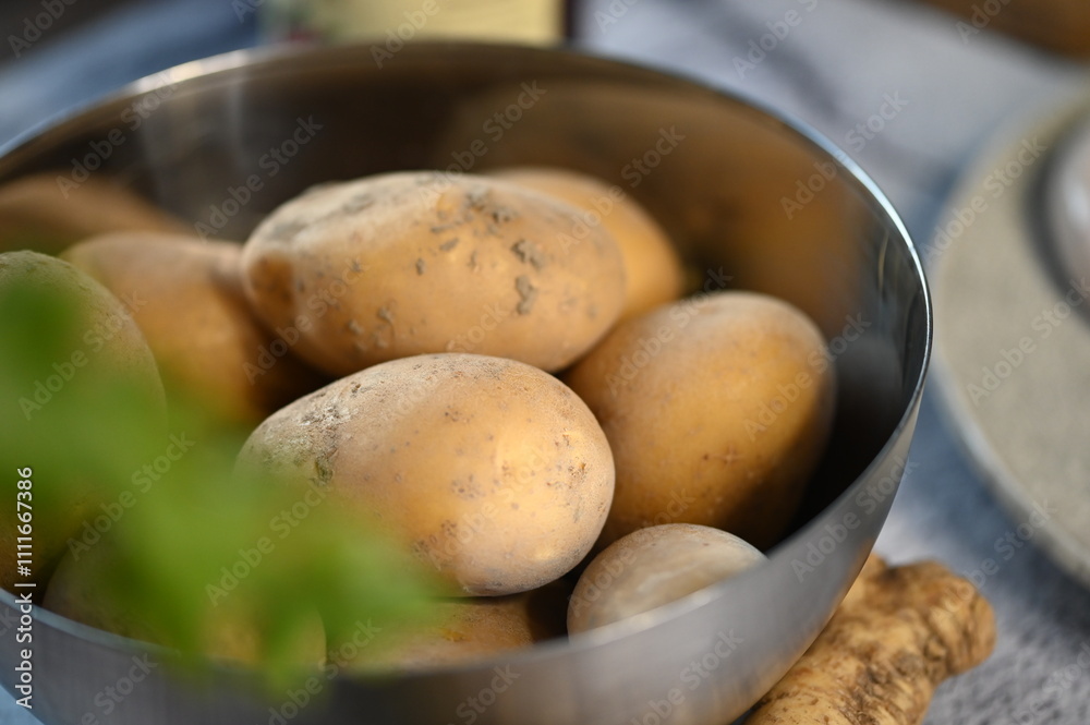 A simple and natural close-up of fresh raw potatoes piled in a bowl. The earthy tones of the potatoes contrast gently with the neutral color of the bowl, creating a rustic and wholesome composition A simple and natural close-up of fresh raw potatoes piled in a bowl. The earthy tones of the potatoes contrast gently with the neutral color of the bowl, creating a rustic and wholesome composition