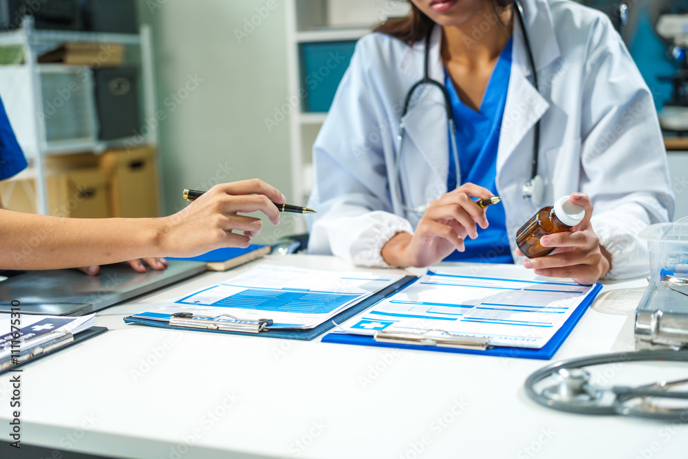 A close-up of two doctors discussing a bottle of medicine at a table in a hospital. They collaborate on patient treatment, analyzing medicine, planning care, and using advanced technology A close-up of two doctors discussing a bottle of medicine at a table in a hospital. They collaborate on patient treatment, analyzing medicine, planning care, and using advanced technology