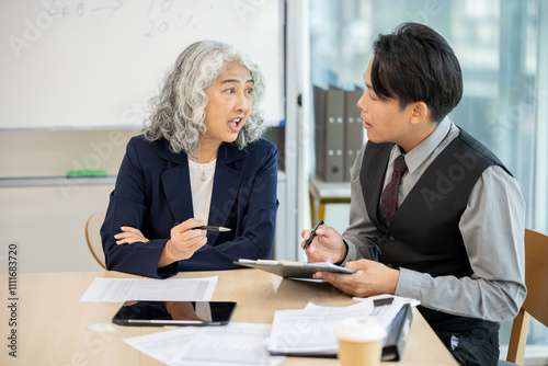 Executives are having a meeting with employees to discuss business planning in a conference room.