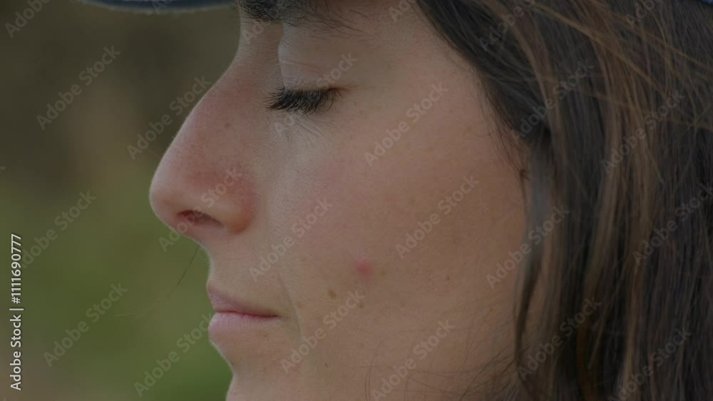 Close-up of a young woman enjoying a calm moment outside Close-up of a young woman enjoying a calm moment outside