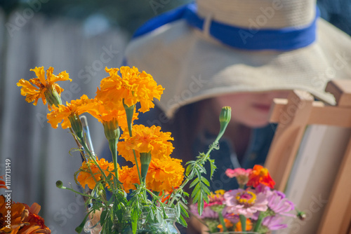 Foto Woman in Hat Painting Marigolds Outside