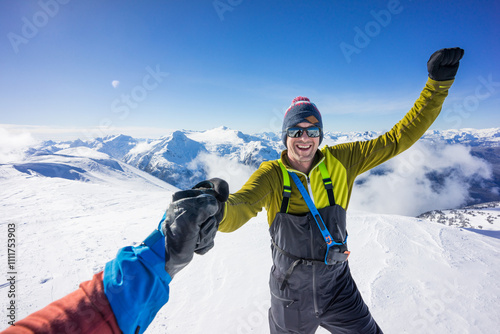 Two backcountry skiers pound their fists after summiting a mountain photo