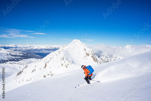 Side view of backcountry skier descending, stunning terrain, Whistler. photo