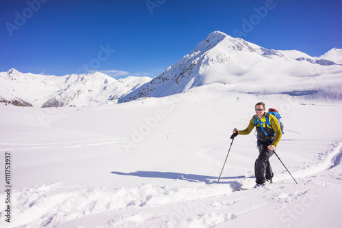 Skier skinning up track in Whistler backcountry, Canada. photo