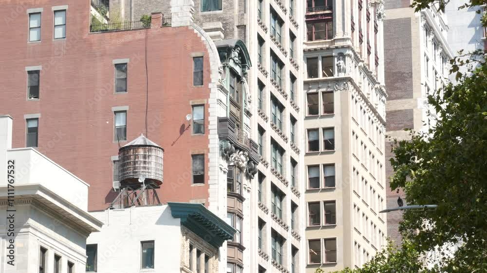 New York City Broadway, Manhattan midtown classic building corner architecture. Urban residential house exterior. Real estate property in USA. Typical brick facade. Rooftop water tower, tank on roof. New York City Broadway, Manhattan midtown classic building corner architecture. Urban residential house exterior. Real estate property in USA. Typical brick facade. Rooftop water tower, tank on roof.