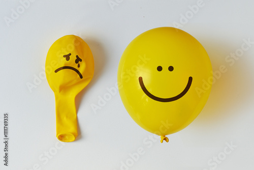 Deflated ballon with sad face and inflated balloon with happy face - Concept of mental health
