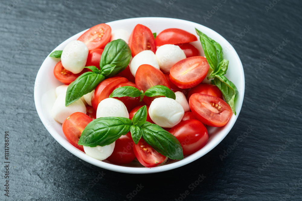 Basil leaves , cherry tomatoes and mozzarella cheese . In bowl food photography Basil leaves , cherry tomatoes and mozzarella cheese . In bowl food photography