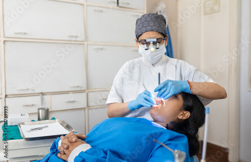 Photography Indian dentist cleaning the mouth of a patient
