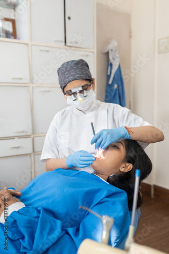 Indian doctor examining a patient in a dental clinic