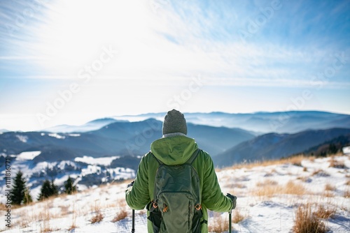 Winter hike for an elderly man in snowy mountains. Active senior looking at beautiful nature around him. photo