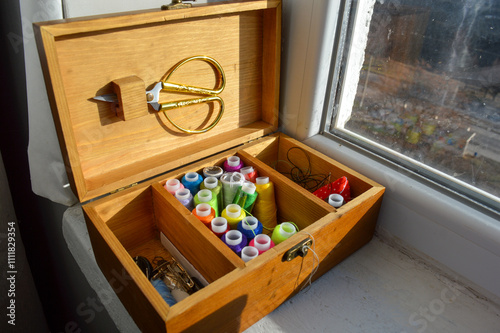 wooden sewing box filled colorful spools of thread сraft tutorials sewing and DIY kits related tools creativity hobbies artisanal work educational basics beginner projects hands-on crafting atmosphere