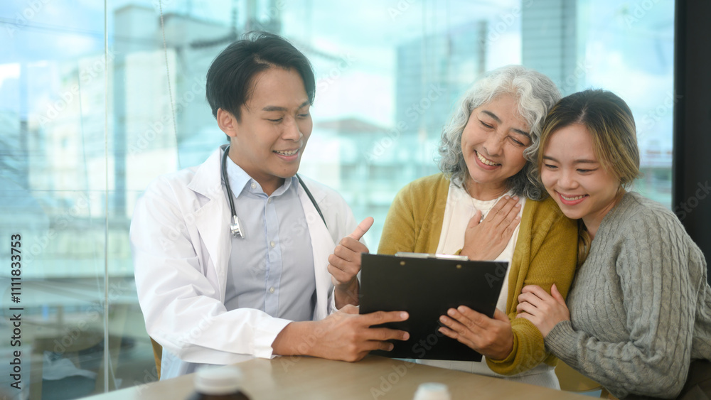 Friendly male doctor sharing positive news with senior patient and her daughter in a bright clinic Friendly male doctor sharing positive news with senior patient and her daughter in a bright clinic