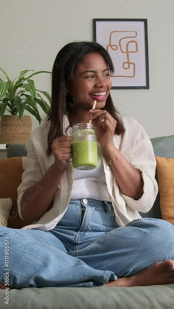 Young woman enjoying green smoothie at home. Vertical video Young woman enjoying green smoothie at home. Vertical video
