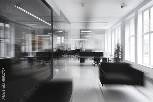 Blurred modern office interior with glass partitions and black furniture.