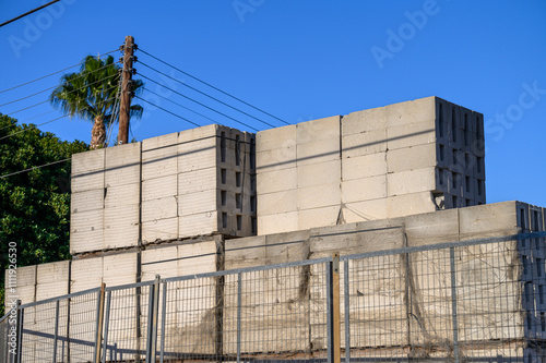Stack of concrete blocks at a construction site against a bright blue sky photo