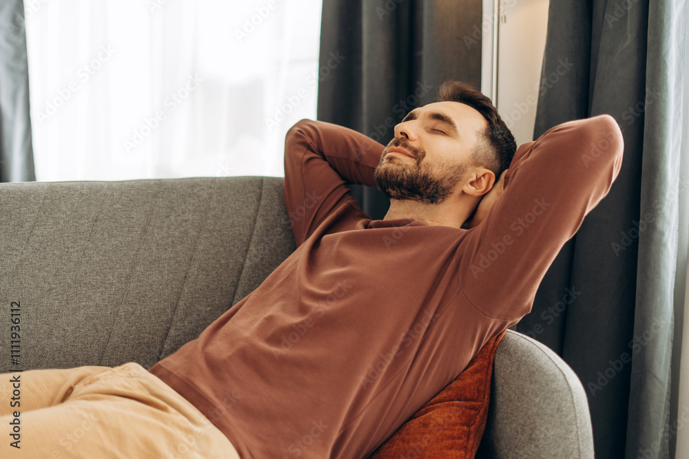 Smiling, handsome Hispanic man relaxing, lying on comfortable sofa in cozy home. Resting concept Smiling, handsome Hispanic man relaxing, lying on comfortable sofa in cozy home. Resting concept