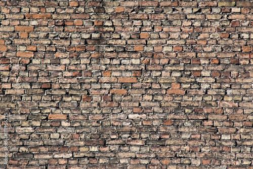 The photo shows a wall made of old bricks